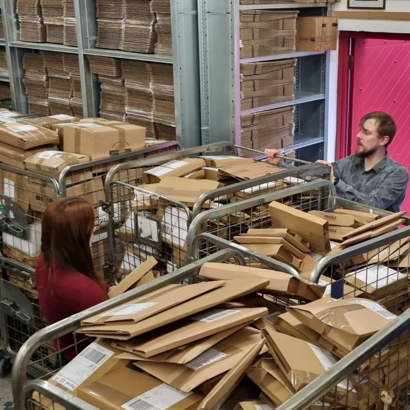 Shipping Manager Shane Crotty with cages of book parcels